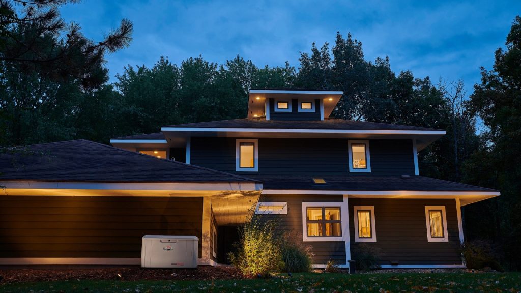 A home is lit up at night with the PowerProtect™ 26kW Standby Generator.