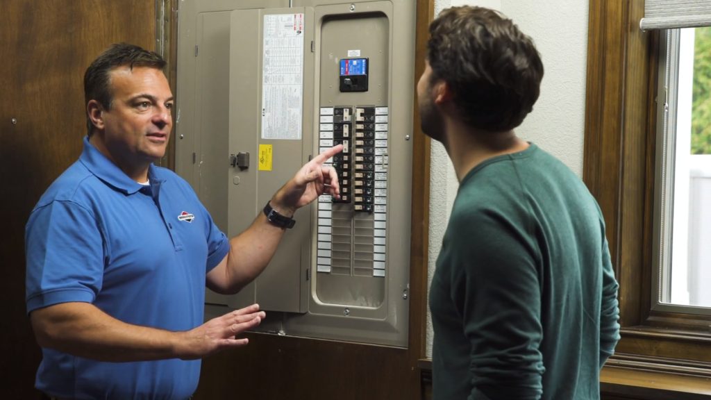 A man talking to a man in front of the PowerProtect™ 26kW Standby Generator.