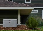 A PowerProtect™ DX 26kW Standby Generator in front of a house.