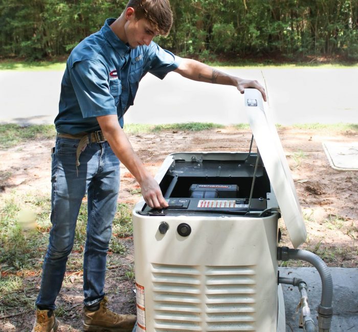 A man working on a generator in the woods.