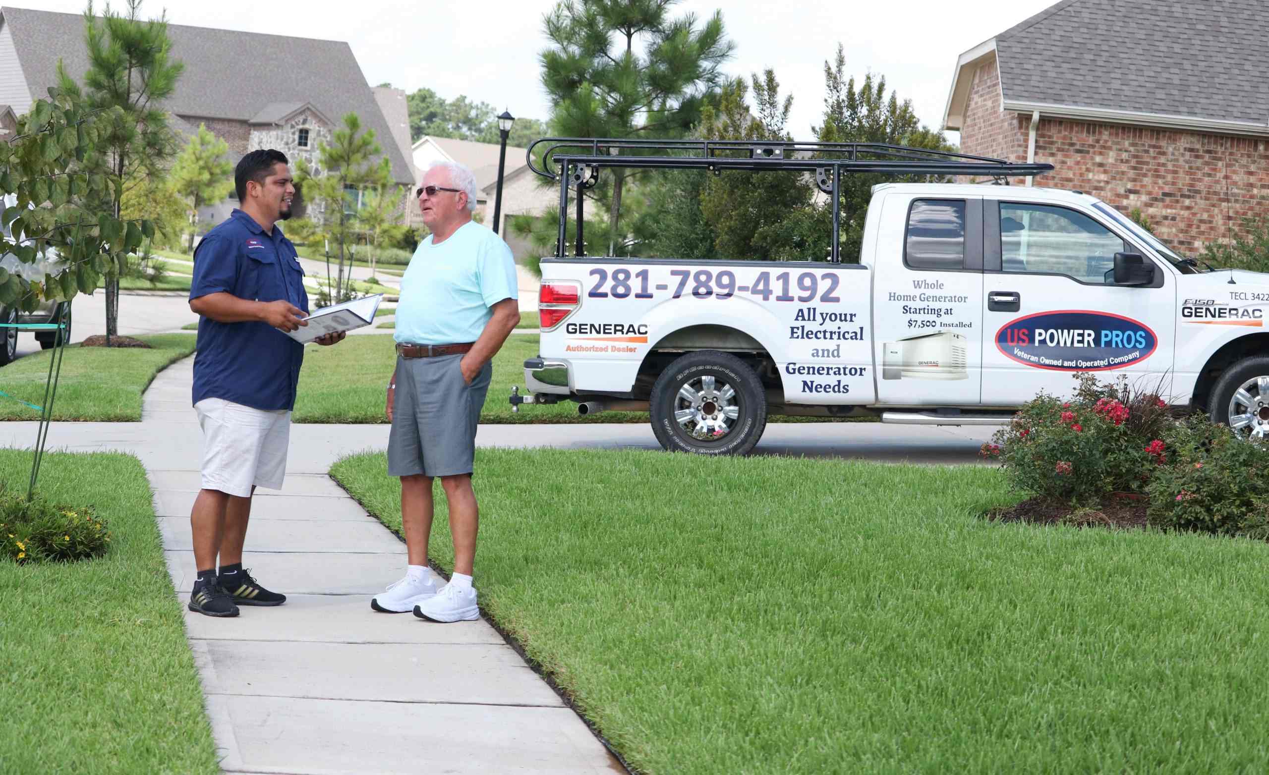 An electrical service expert and a client near a pickup truck